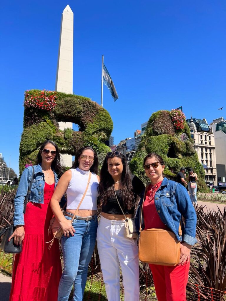 Grupo de turista em frente ao Obelisco de Buenos Aires em um dia ensolarado.