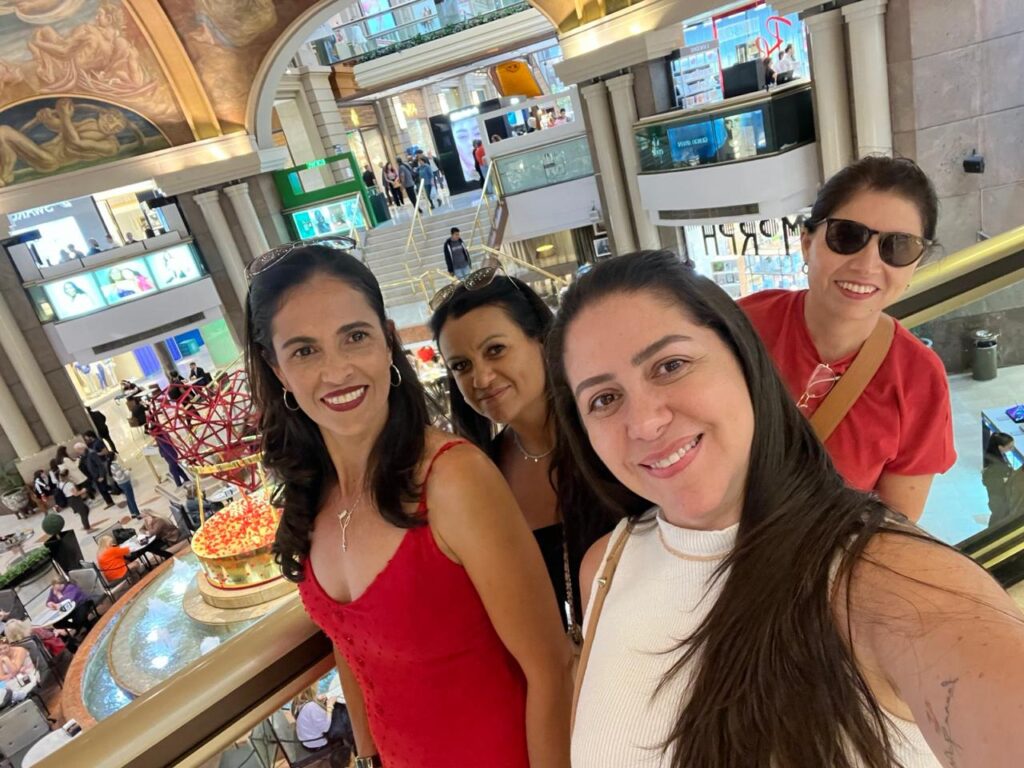 Grupo de turistas nas Galerías Pacífico, em Buenos Aires, com área central iluminada ao fundo.