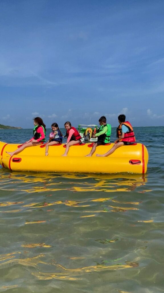turistas no banana boat em frente ao resort vila gale do cabo