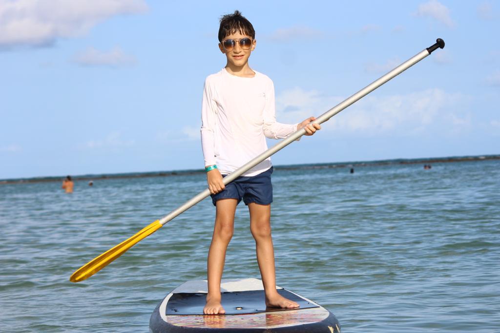 turista fazendo stand up na praia dos carneiros em frente ao bora bora